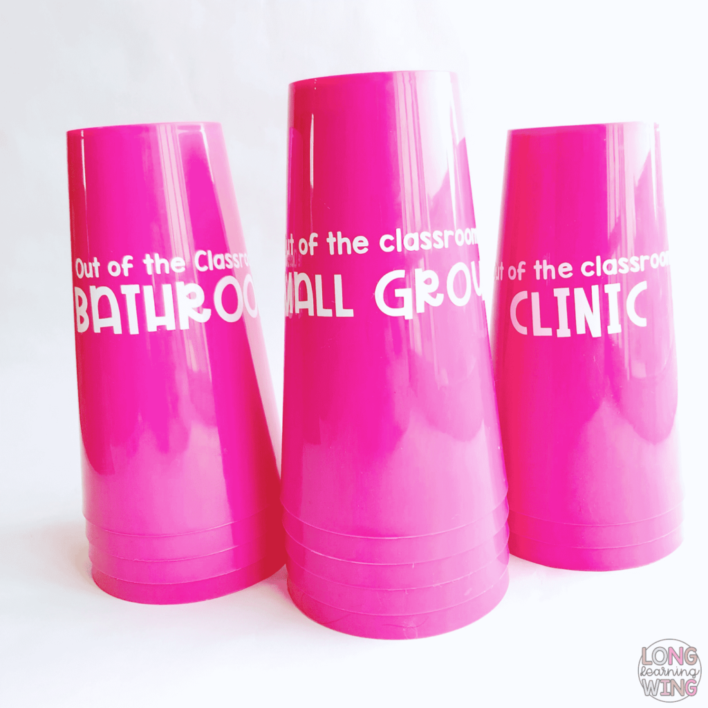 three cups with white vinyl lettering to use in classroom