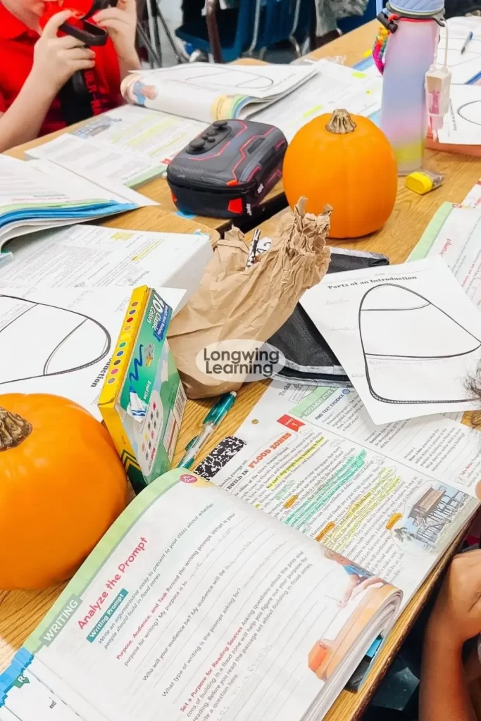 a table with Wonders 4th grade books and pumpkins