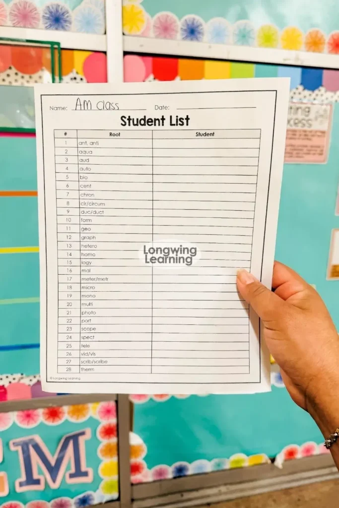 Teacher displaying a student checklist used to track completed ornaments in a Christmas Greek and Latin roots activity